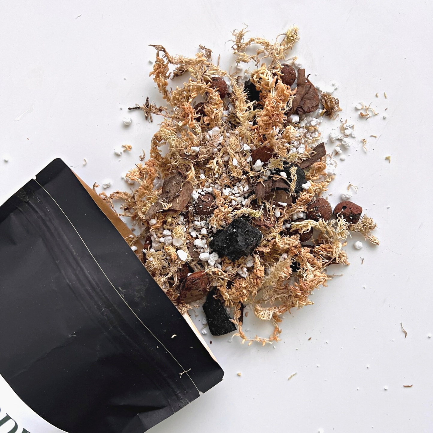 A bag of Birdy's Plants 2L Premium Orchid Soil Mix being spilled out .