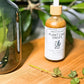 Plant Care Drops bottle with Hoya plants in background, natural solution for indoor plant care and pest prevention