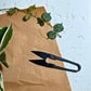 Pruning scissors with Hoya plants in background, indoor plant care tool for trimming and precise houseplant maintenance